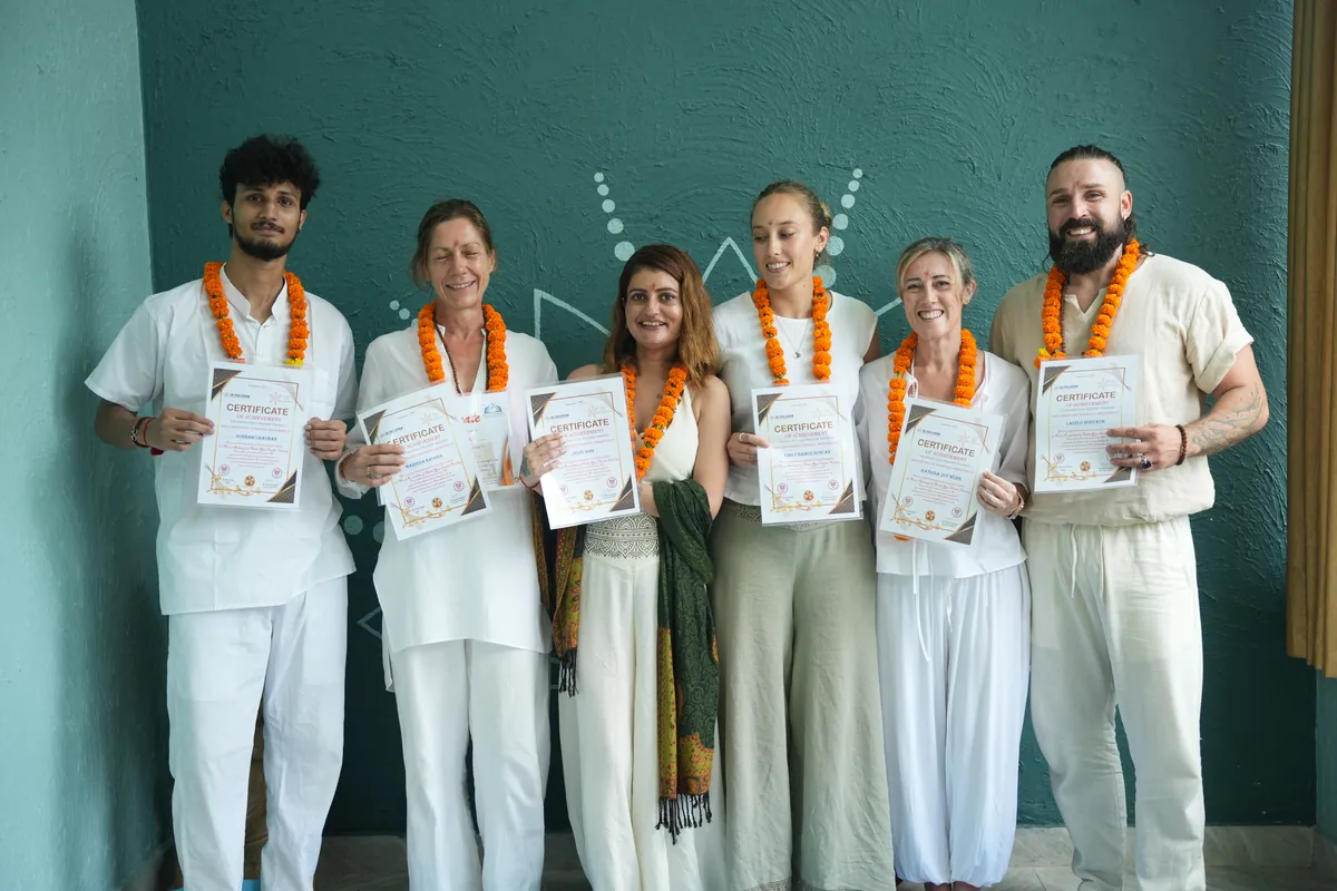 Students holding Yoga Alliance certificates after graduating from Sri Yoga Ashram in Rishikesh