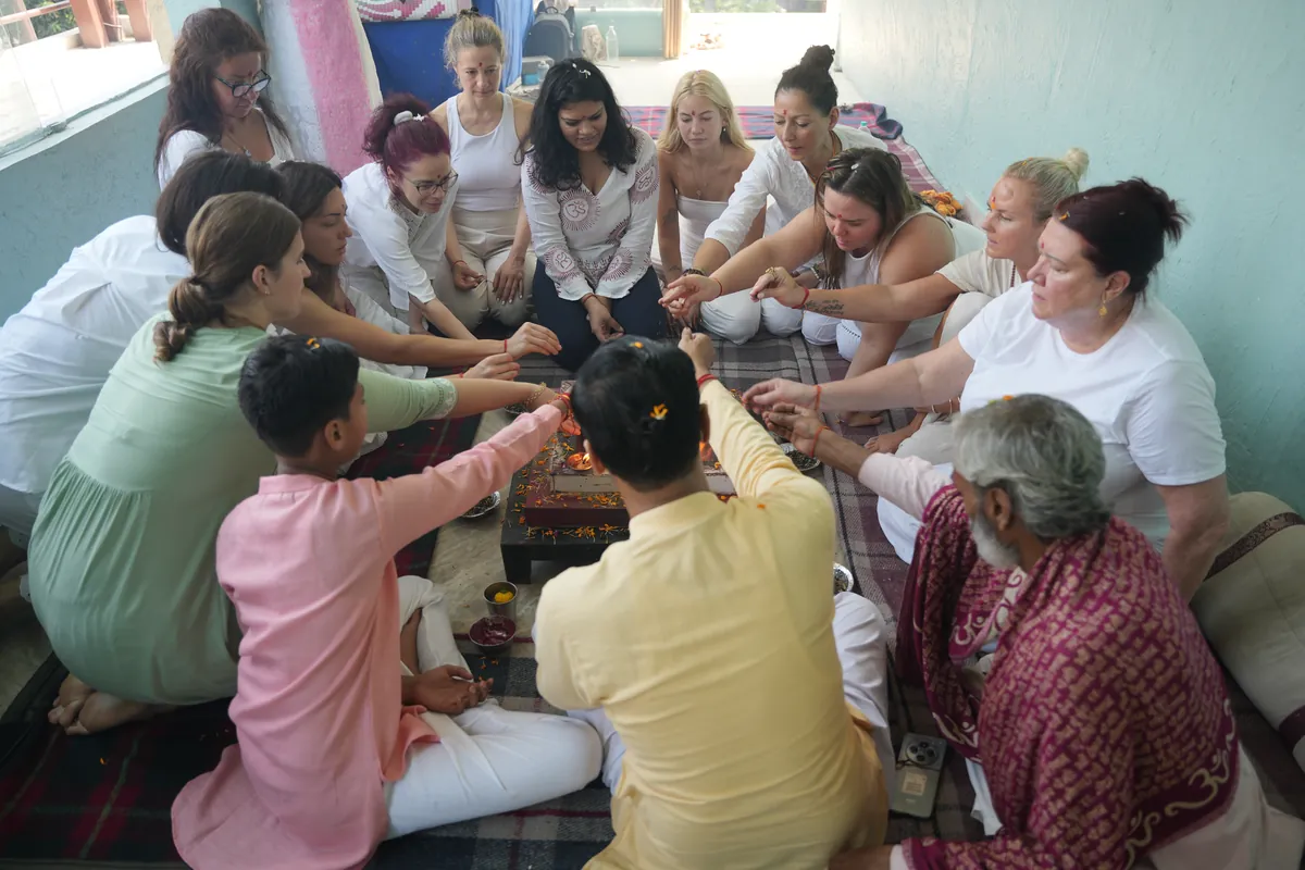 Students seated in a circle around the ceremonial fire during a yagna at Sri Yoga Ashram