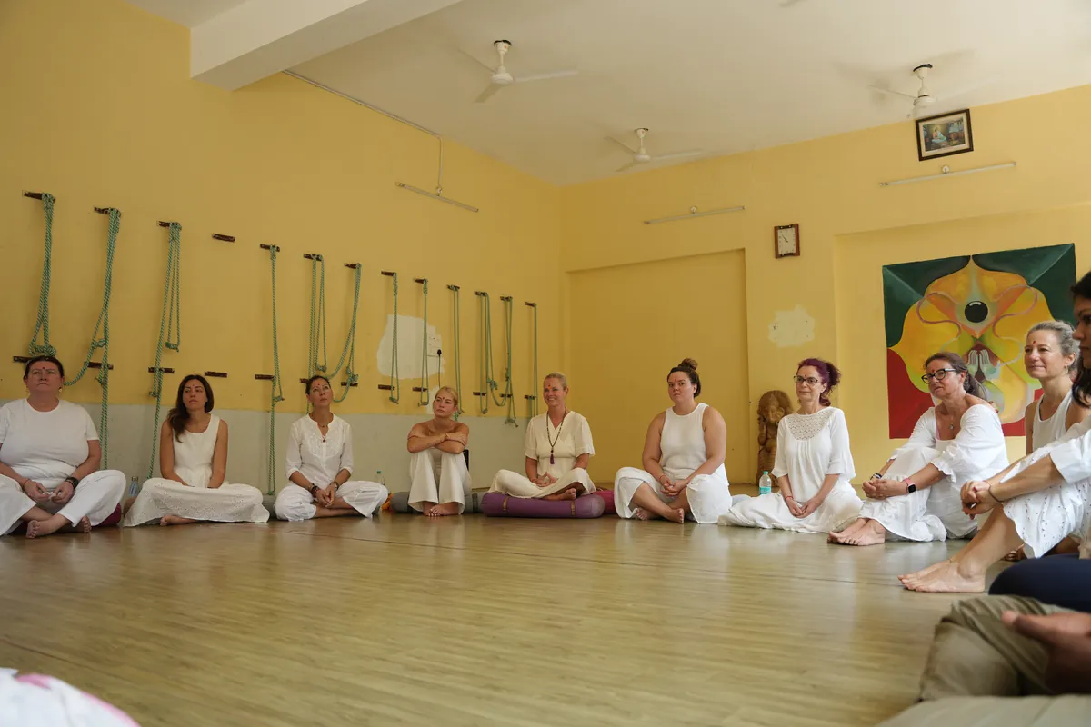 Meditation teacher training group sitting in a circle in the yoga hall at Sri Yoga Ashram