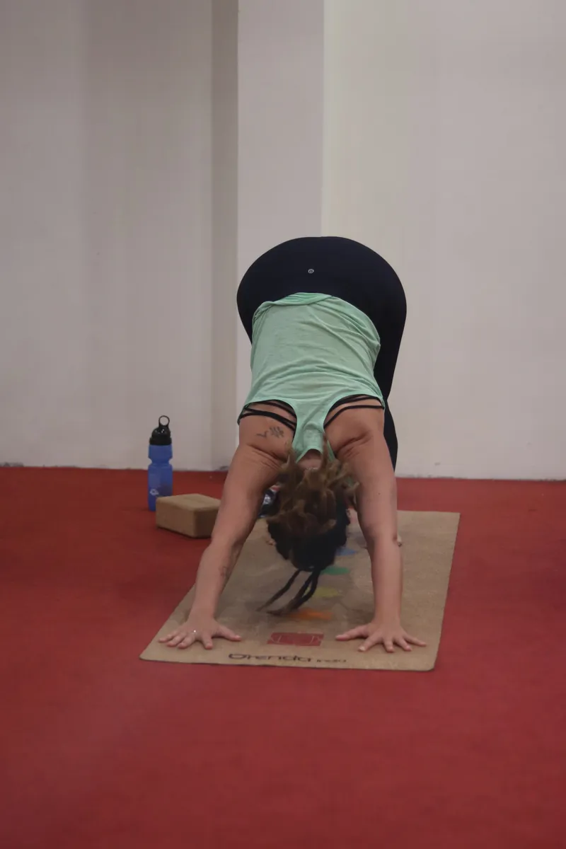 Student in a standing forward bend in the yoga hall during yin yoga training