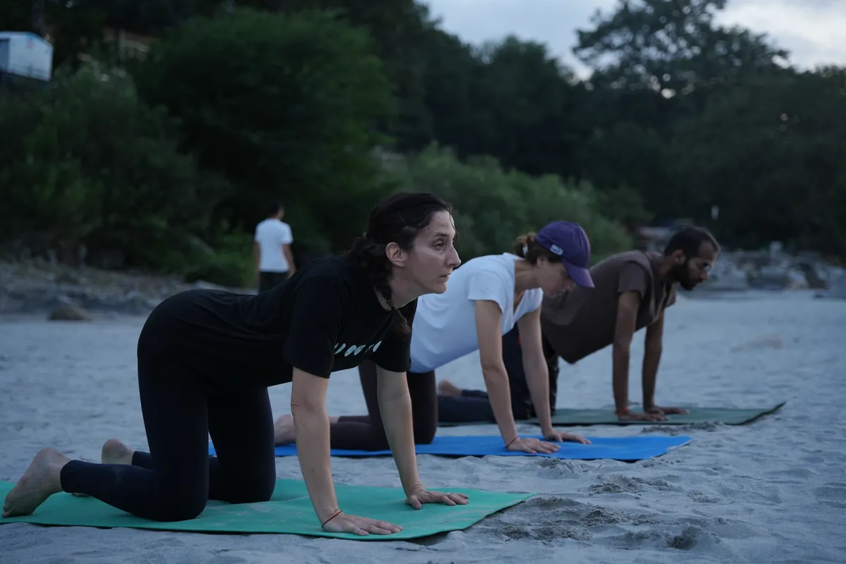 Student in a tabletop posture on a mat outdoors in Rishikesh during yin yoga training