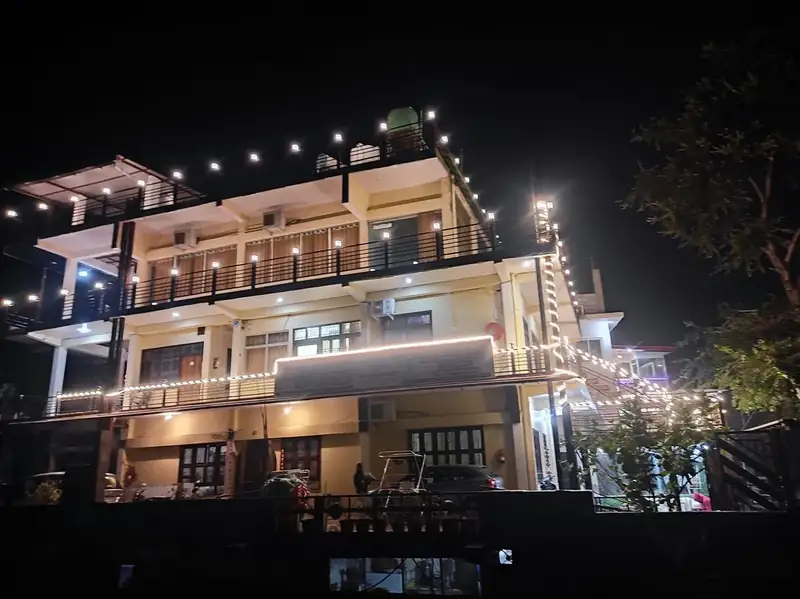 Ashram building in Rishikesh lit with string lights and balconies at night