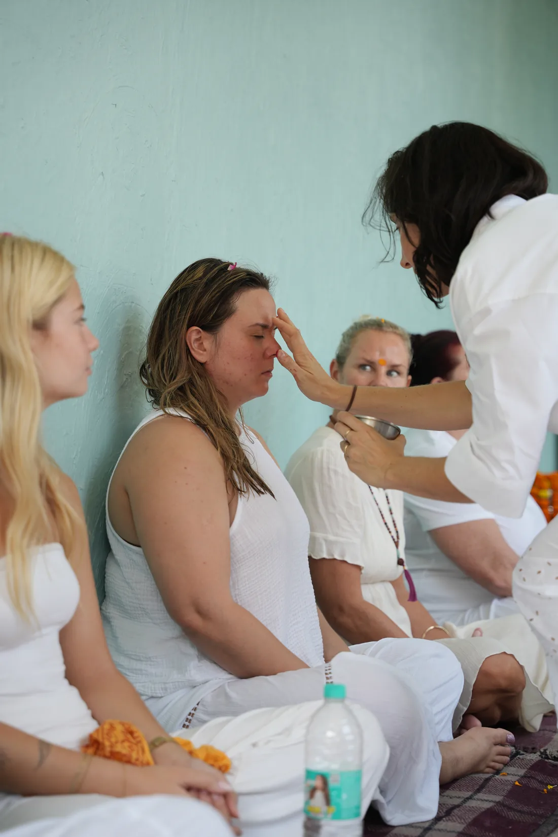 Tilak blessing applied to student forehead during welcome ceremony at Sri Yoga Ashram Rishikesh