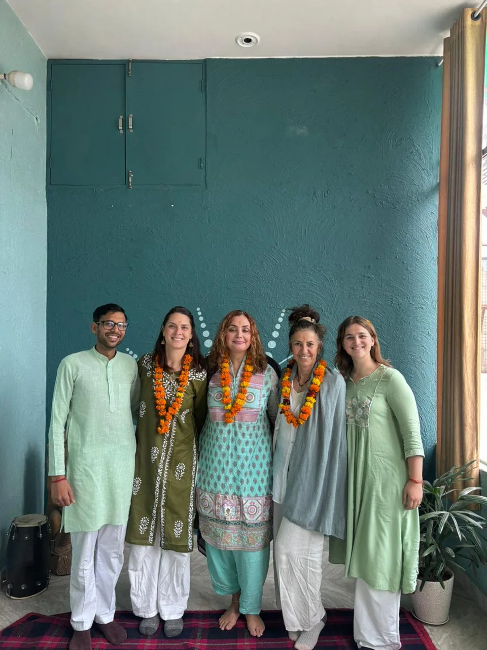 Yoga teacher training students wearing marigold garlands at Sri Yoga Ashram Rishikesh