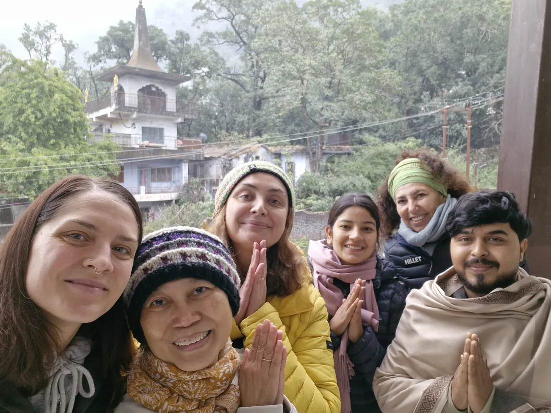Students greet with namaste beside a hillside temple near Sri Yoga Ashram Rishikesh