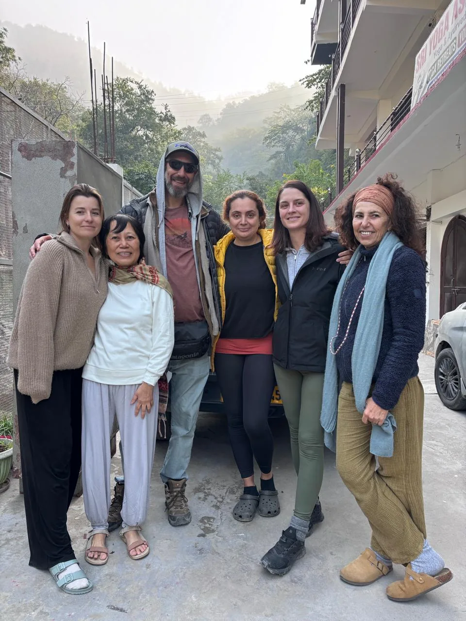 Group of students standing outside the Sri Yoga Ashram building in the Rishikesh hills