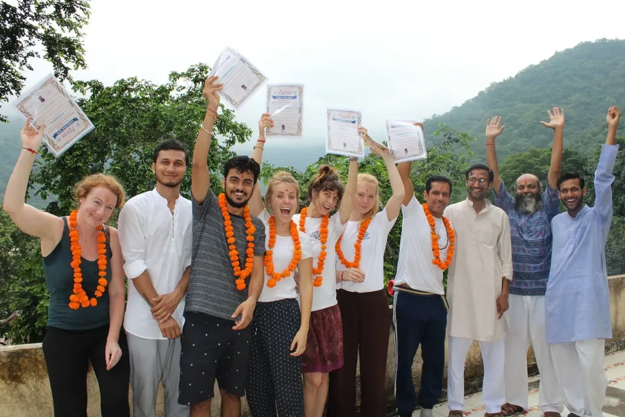 Sri Yoga Ashram graduates in Rishikesh holding their 200 hour yoga teacher training certificates